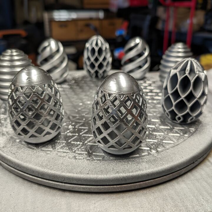 Set of silver lattice and spiral dragon eggs on a display base