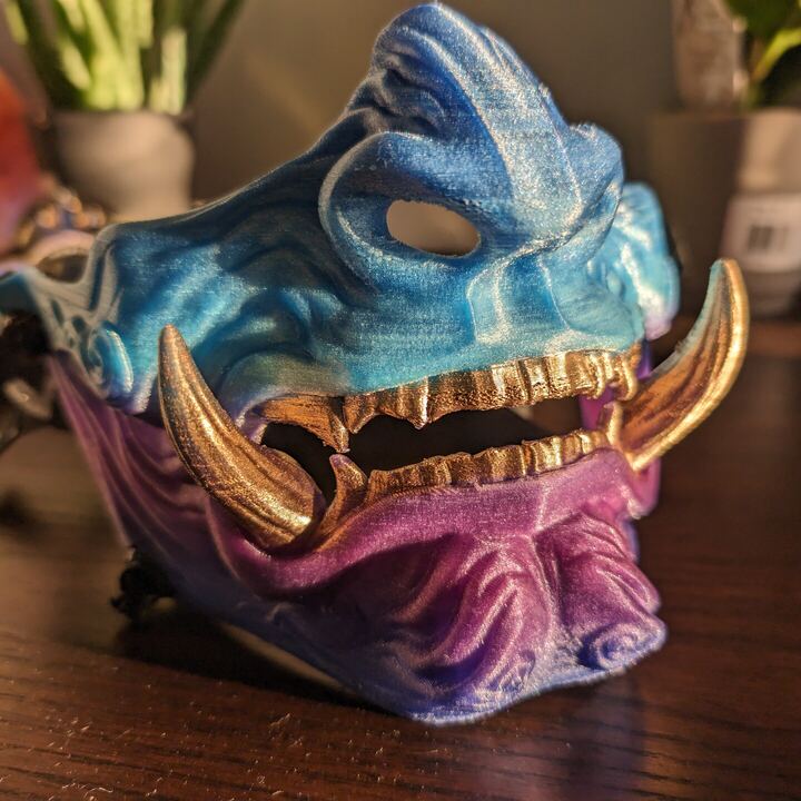 Oni demon mask in teal and magenta with gold tusks and teeth